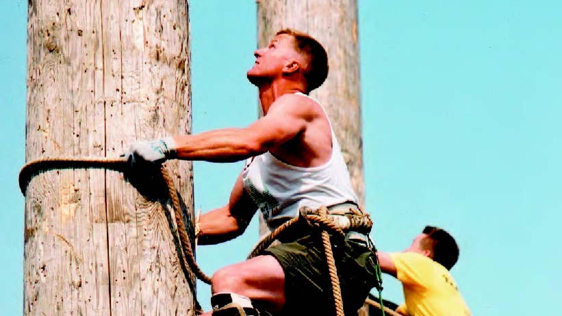 Greg Hart scales a log pole as part of a lumberjack competition.